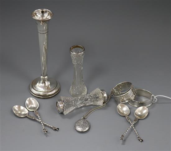Two silver napkin rings, a silver vase, silver mounted vase, four silver spoons, silver locket and a glass knife rest.